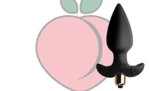Black anal wedge with vibration against a peach background