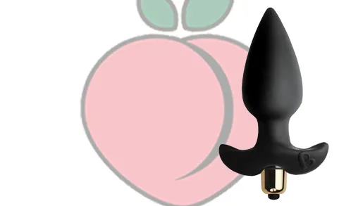 Black anal wedge with vibration against a peach background